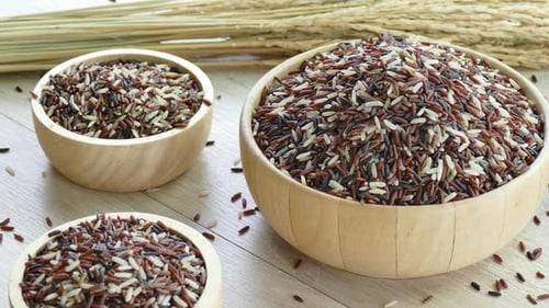 Bowls of Uncooked Brown Rice on Wooden Table