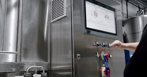 Operator touches control screen in clean modern factory