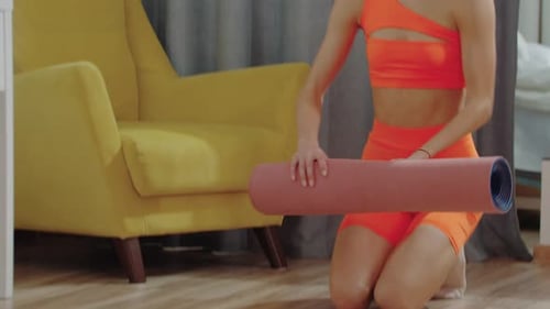 Woman Unrolls Yoga Mat in Home Living Room
