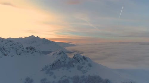 Snowy Mountains at Sunrise Above Clouds