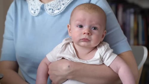 Young Mother Holding a Newborn Baby Boy in Her Arms