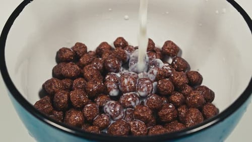 Close Up. Milk Is Poured Into Breakfast Cereals Chocolate Corn Balls