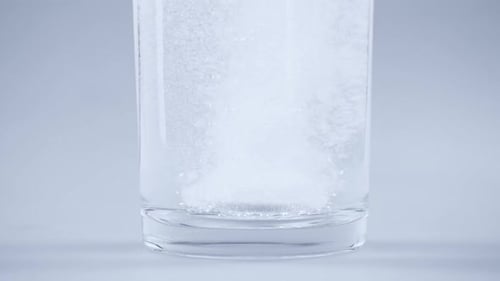Effervescent Tablet Dissolving in Clear Glass of Water