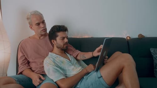 Young Adults Relaxing Together on Couch with Tablet