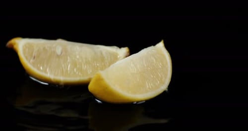 Slices of Fresh Lemon Falling Into Water with a Splash.
