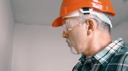 Construction Worker Wearing Safety Equipment in a White Room