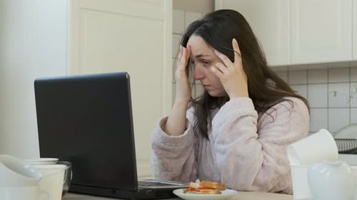 Woman Working on Laptop in Kitchen at Home