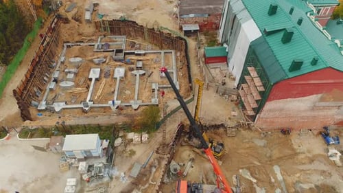 Truck Cranes and Buildings Foundation Near City Street
