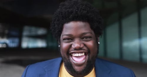 Happy african curvy man laughing on camera outdoor