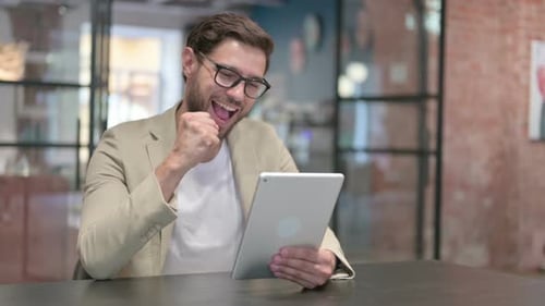 Young Adult Celebrating Success on a Tablet