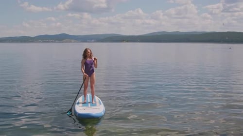 Woman Paddleboarding on a Lake on a Sunny Day