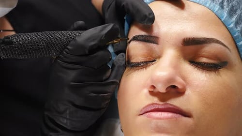 Woman Receiving Eyebrow Tattooing Procedure Close Up