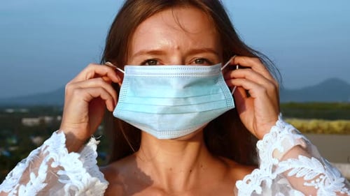 Close Up of Woman Looking at Camera and Wearing Facial Health Mask