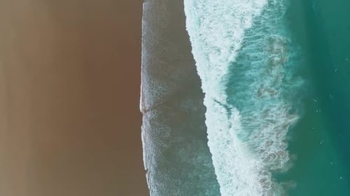 Aerial Top View on Ocean Waves and Sandy Beach