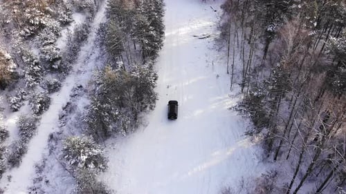 Classic Gray Car Driving Through the White Winter Snowy Forest on Country Road