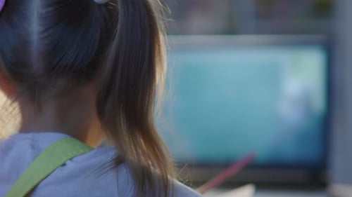 Schulmädchen studiert online auf Laptop zu Hause