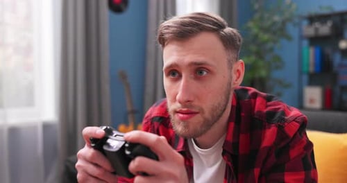 Enthusiastic Young Man Playing Video Game at Home