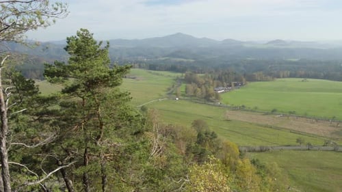 A View of a Green Nature with Trees, Hills, Mountains, and Small Residential Villages.