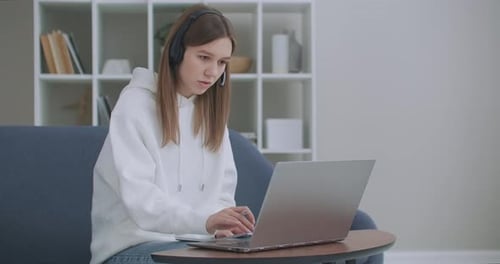 Woman Video Conferencing and Taking Notes at Home