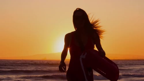 Female lifeguard running along the beach