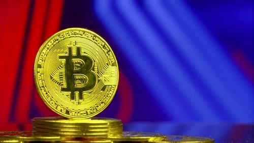 Goldener Bitcoin steht auf einem Stapel von Münzen mit Blockchain-Hintergrund.