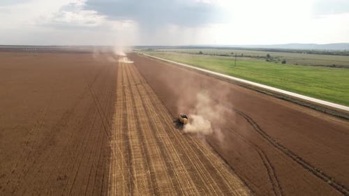 Aerial View of Harvester Machines Working in Wheat Field