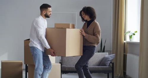 Couple Carries Moving Boxes and Celebrates