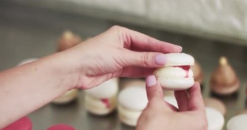 Connecting The Two Halves Shells Of Macarons Decorated With Jam And Ganache