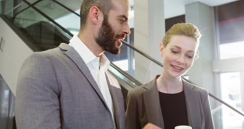 Smiling Business Colleagues at Work With Tablet