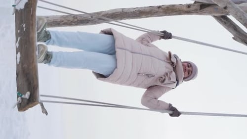 Woman Swinging on a Swing Set in Winter