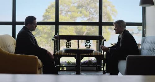 Two Men in Suits Discuss Business Indoors