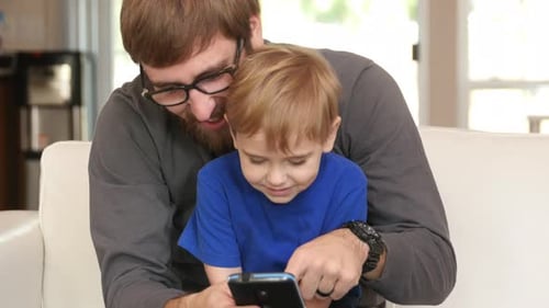 Father and Child Looking at Phone Together