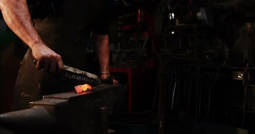 Mittelteil des Schmieds mit Drahtbürste auf heißem Eisen