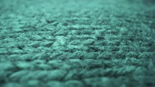 Extreme detail view of sheep wool cloth texture flowing in macro dolly shot.