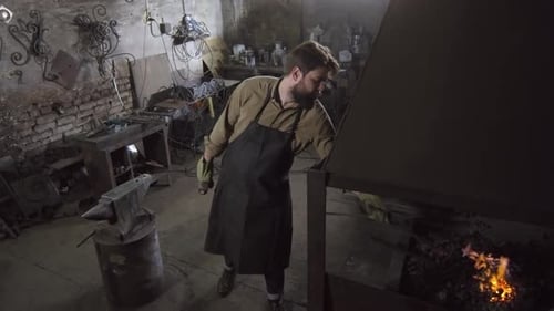 Male Worker Forging Metal Billet in Workshop
