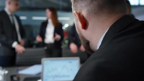 Stock Market Trader Monitoring Online Chart in Office