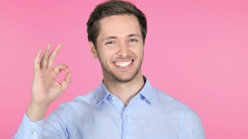 Young Man Gives Approval on Pink Background