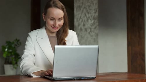 Woman Celebrates While Working on Laptop Computer