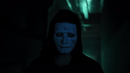 Hooded Figure with Mask and Cleaver in Dark