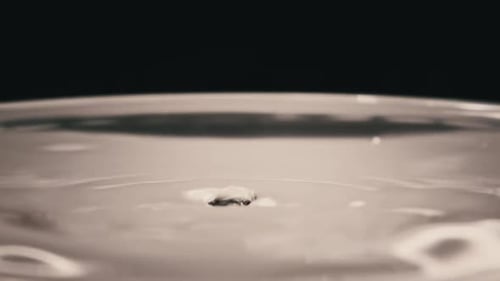 Water Drop Falls on the Water Surface in Slow Motion Macro Shot
