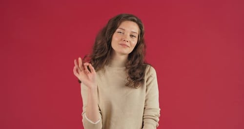 Cute Pretty Caucasian Woman Young Girl Model Showing Okay Sign Over Red Studio Background