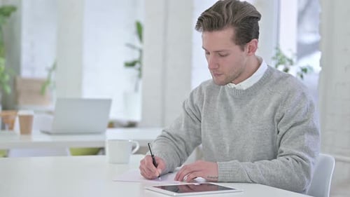 Hardworking Creative Young Man Doing Paperwork in Loft Office
