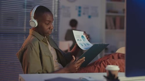 Homme noir au casque travaillant au bureau la nuit