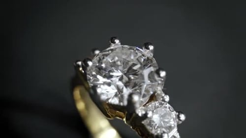 Gros plan extrêmement détaillé de la bague en diamant lors de la rotation sur fond sombre