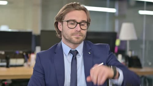 Man Looks at Watch in Office Waiting
