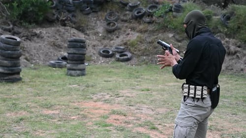 Primer plano de tiro de hombre disparando pistola en campo al aire libre
