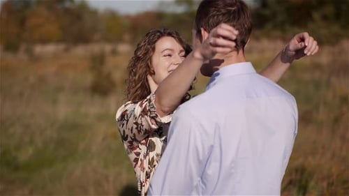 Young Couple Walking on a Meadow