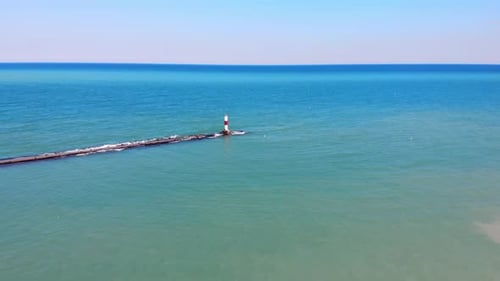 Aerial View Red Lighthouse By the Sea on a Sunny Day. View From a Quadcopter on a Red Lighthouse.