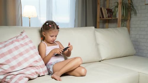 Young Girl Using Smartphone on Couch