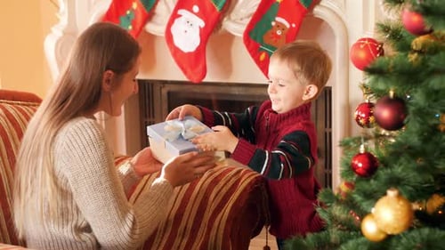 Boy Giving a Gift to Woman at Christmas
